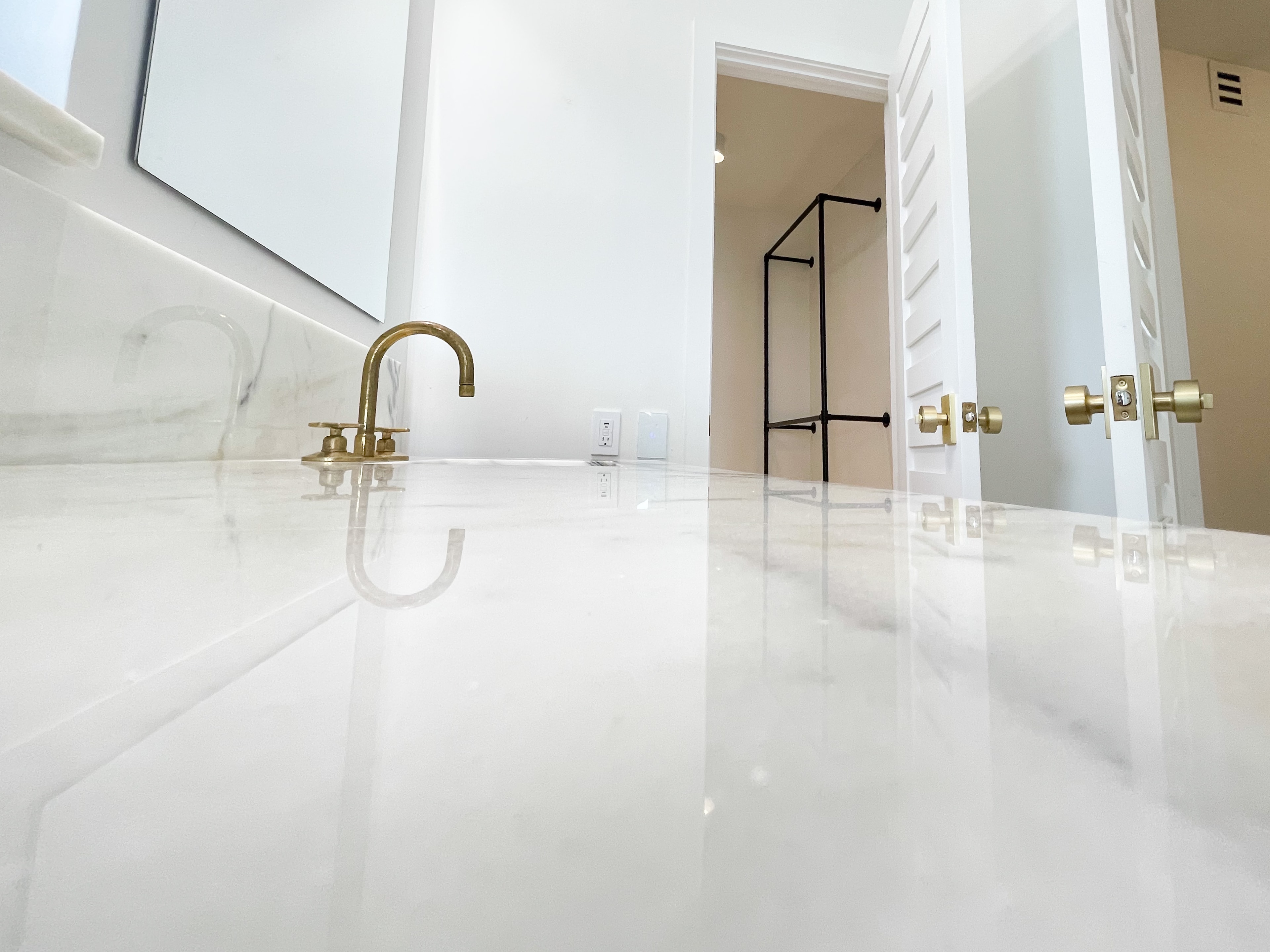 Close-up of polished marble vanity counter with brass faucet