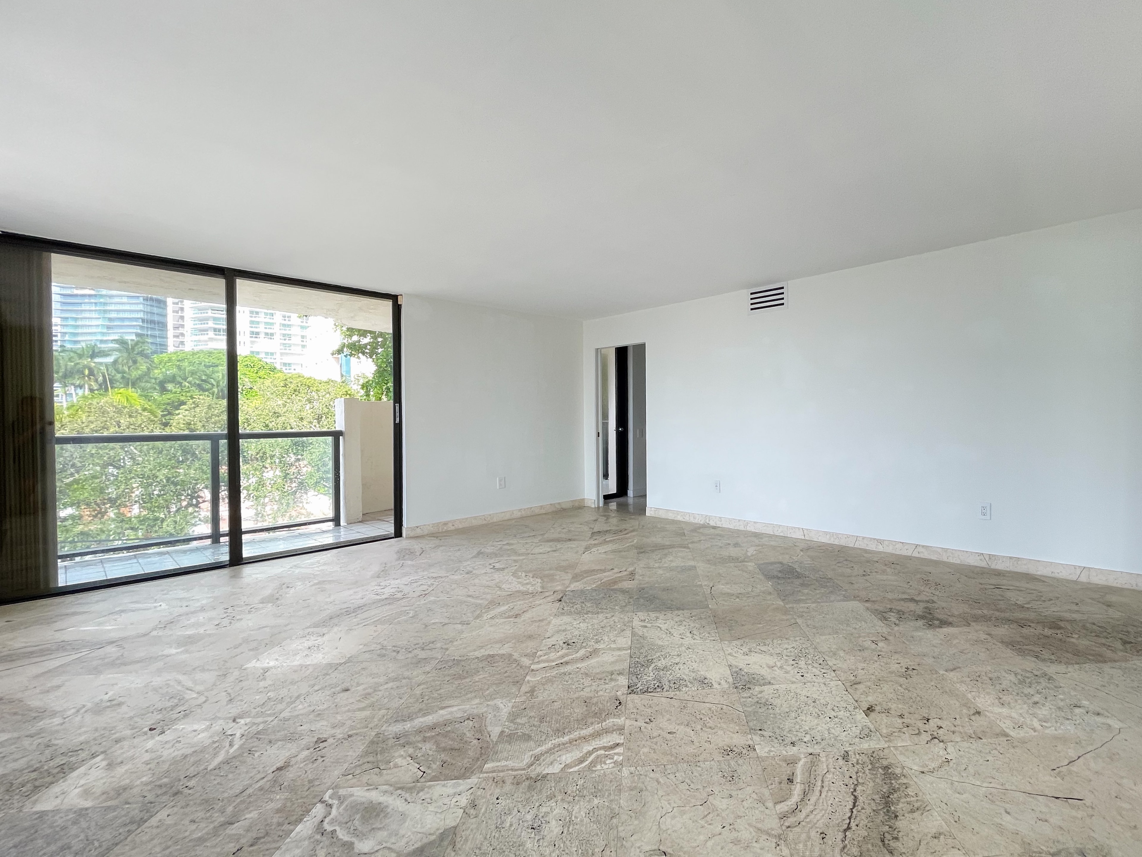 Bright bedroom with marble floors and corner floor-to-ceiling windows