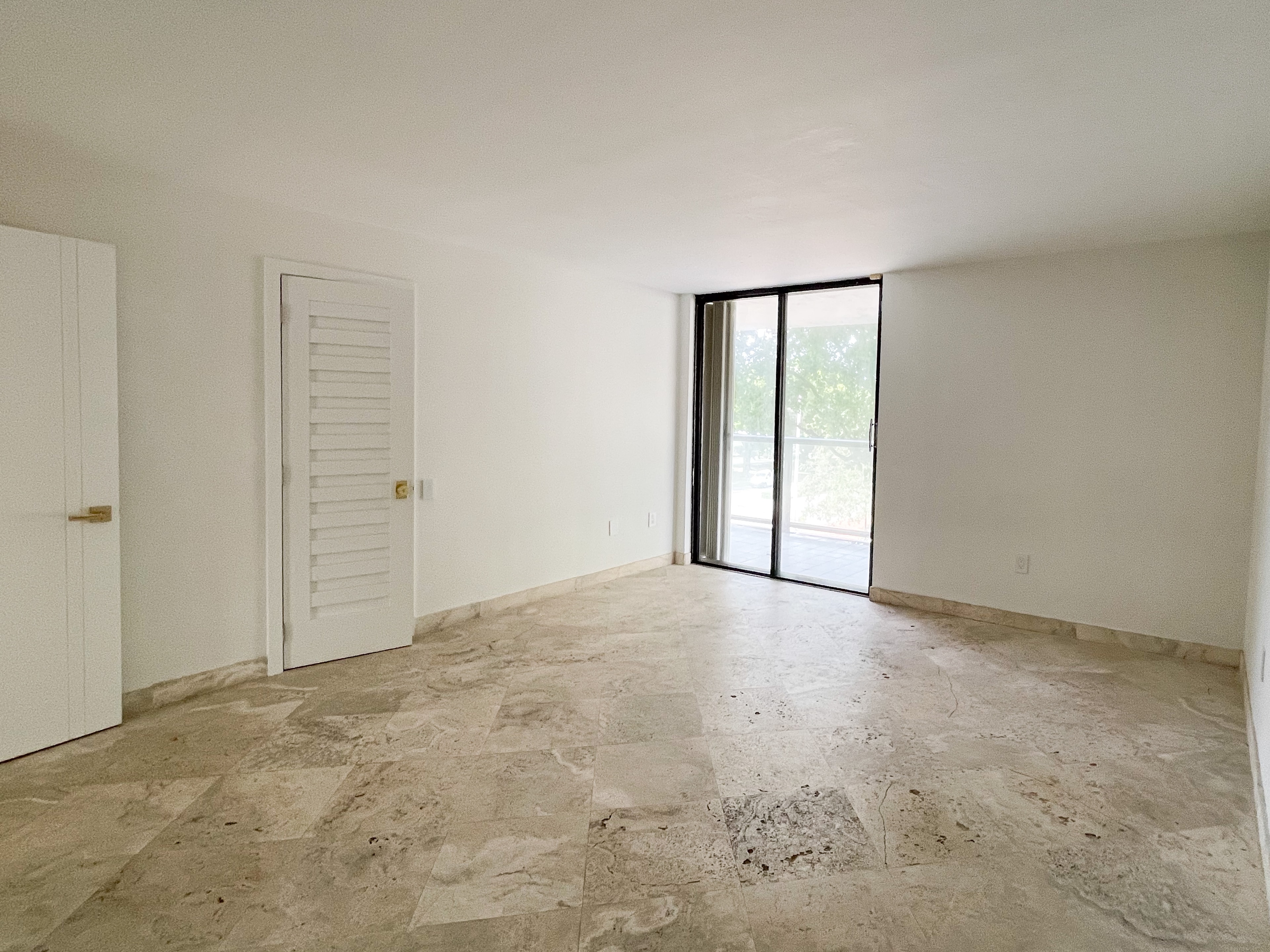 Bedroom with louvered closet doors and balcony access