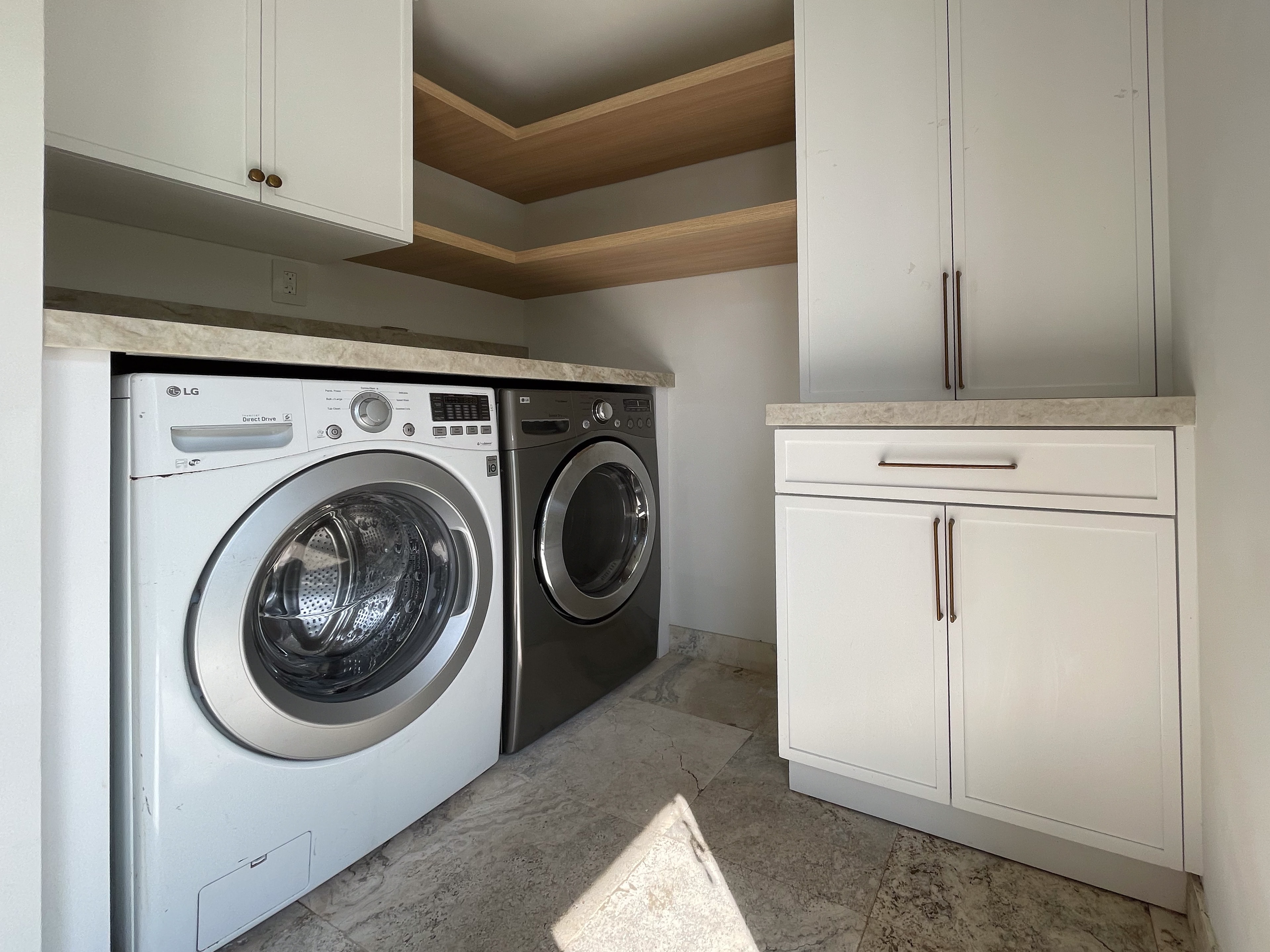 Dedicated laundry room with LG washer and dryer, marble countertop, and custom cabinetry