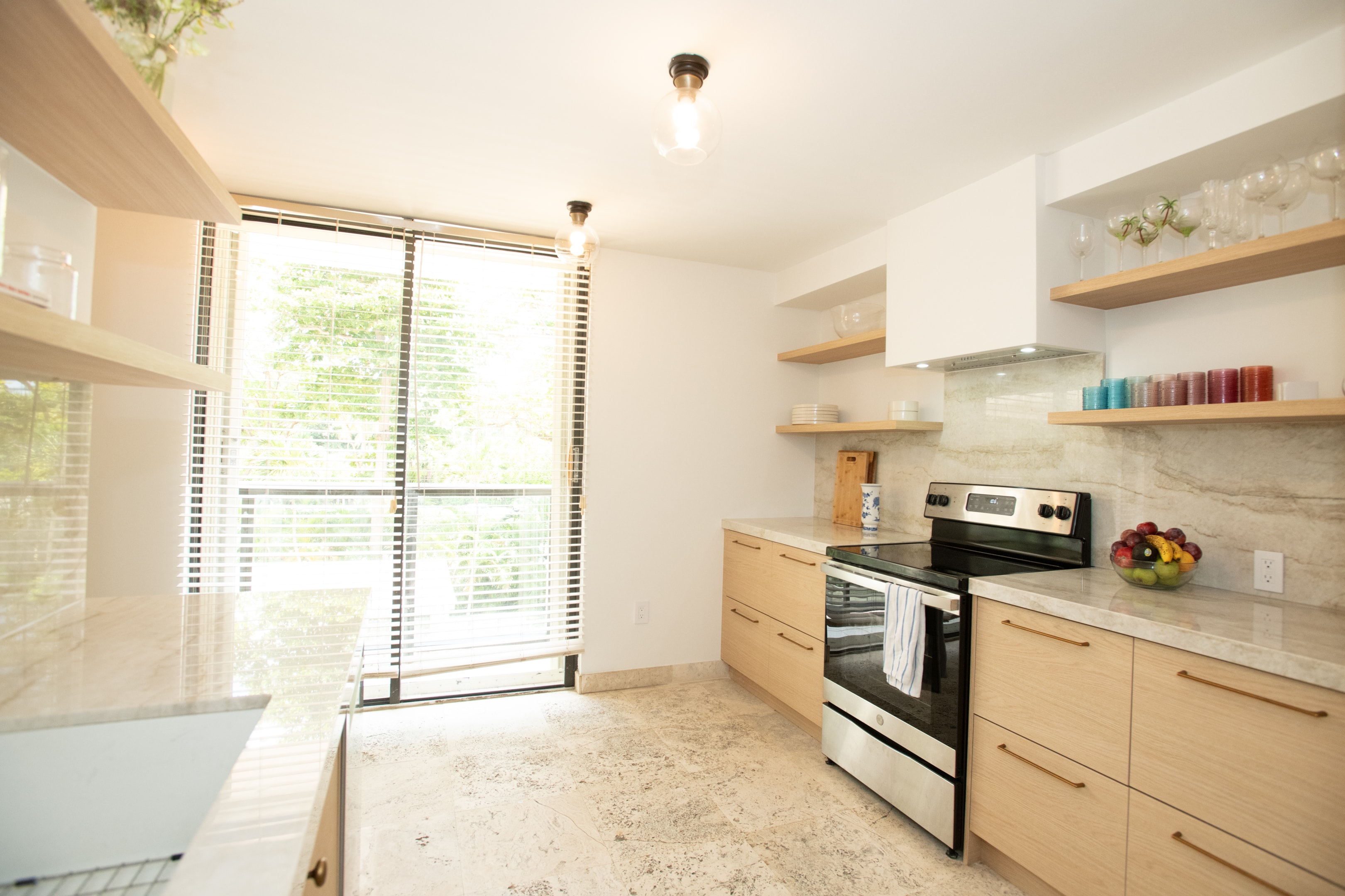 Kitchen with stainless range, marble backsplash, and floor-to-ceiling garden view