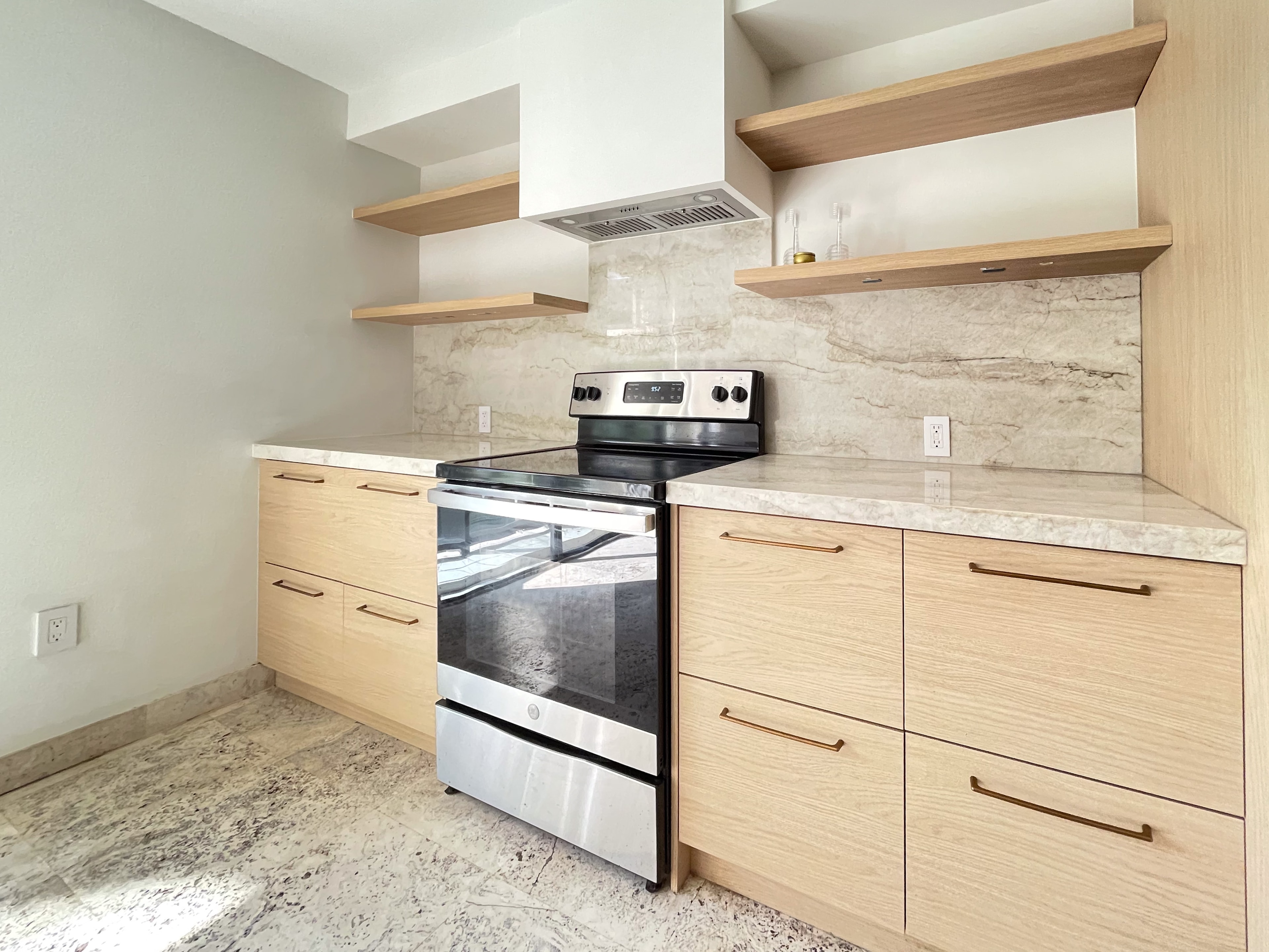 Kitchen range wall with full-height marble slab backsplash and open wood shelving