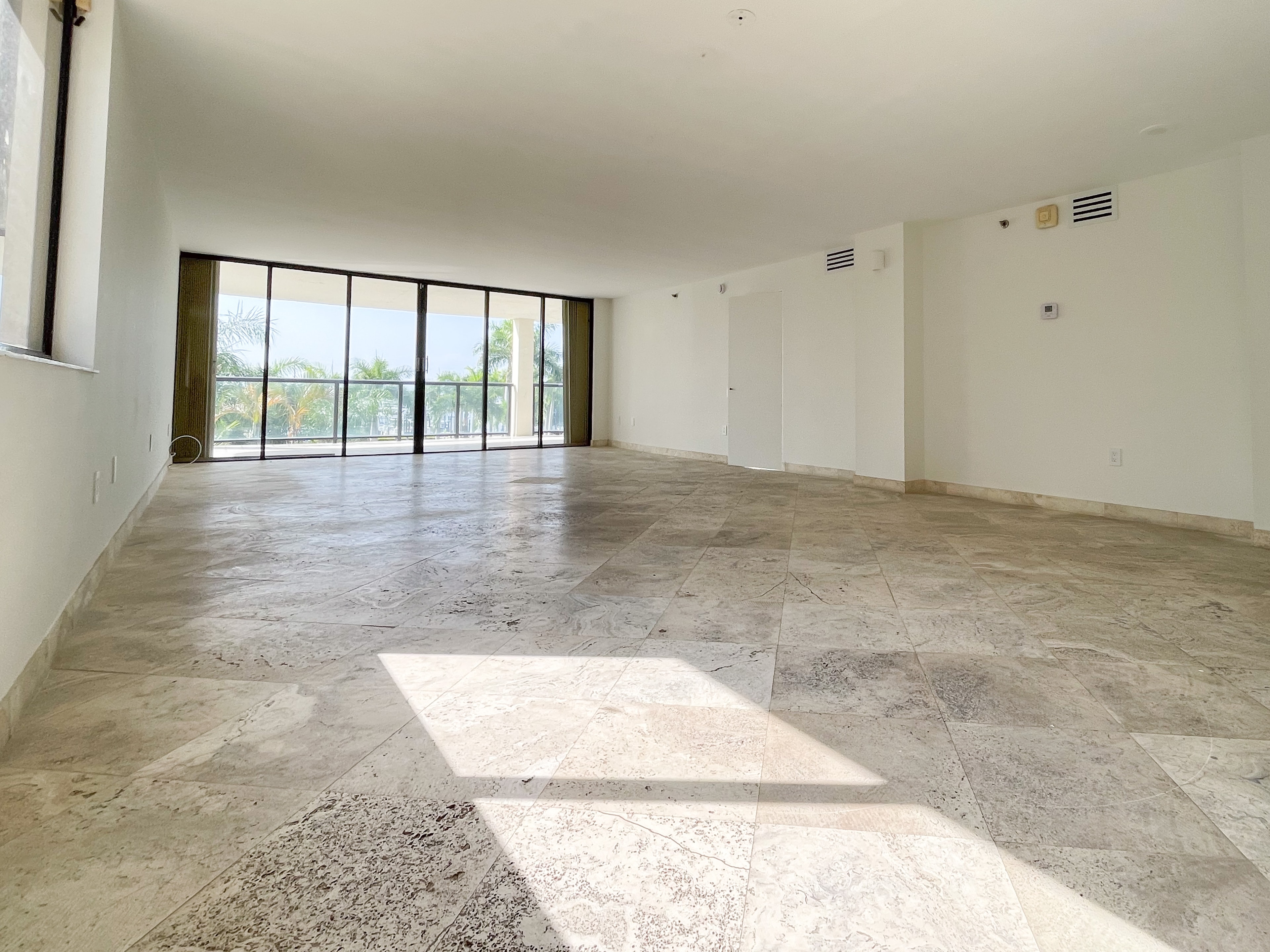 Bright living room with travertine floors and bay light